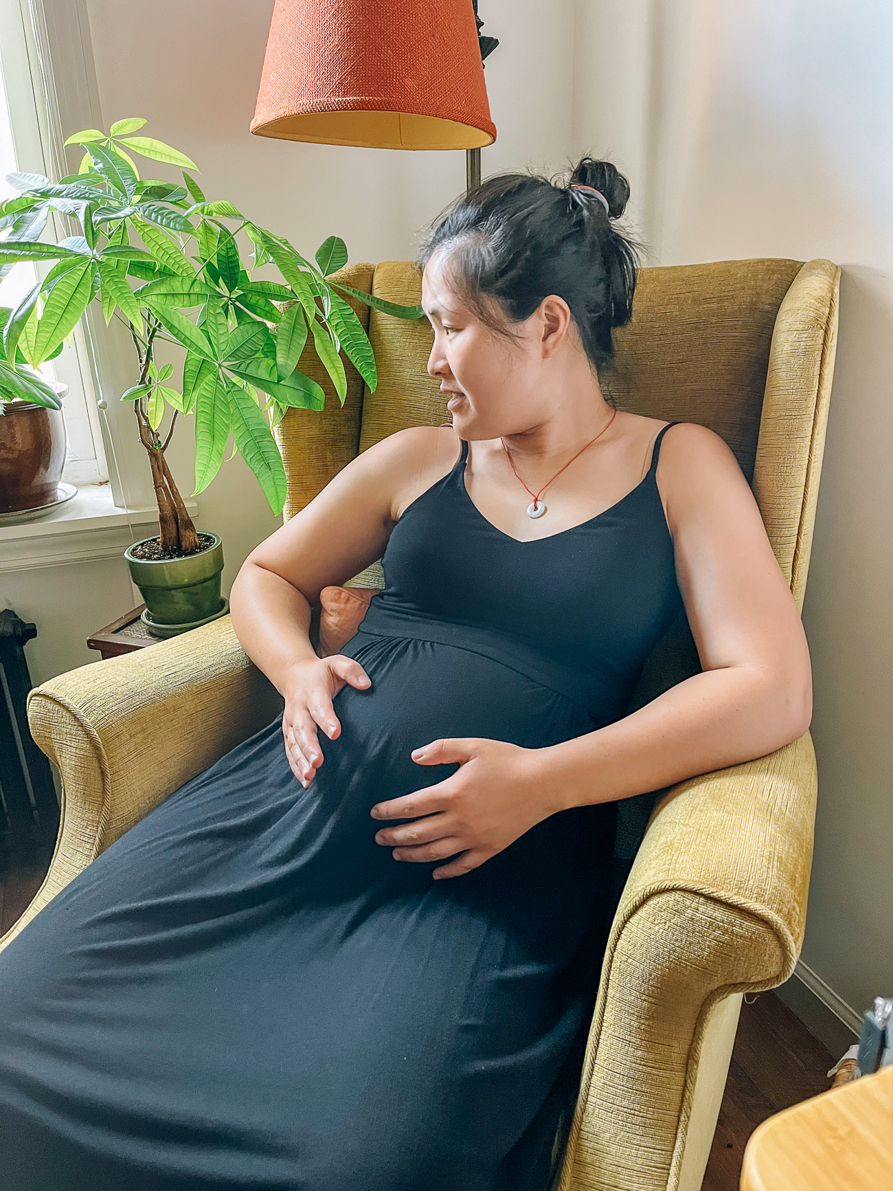 Pregnant Sarah from The Woks of Life sitting in green chair next to window