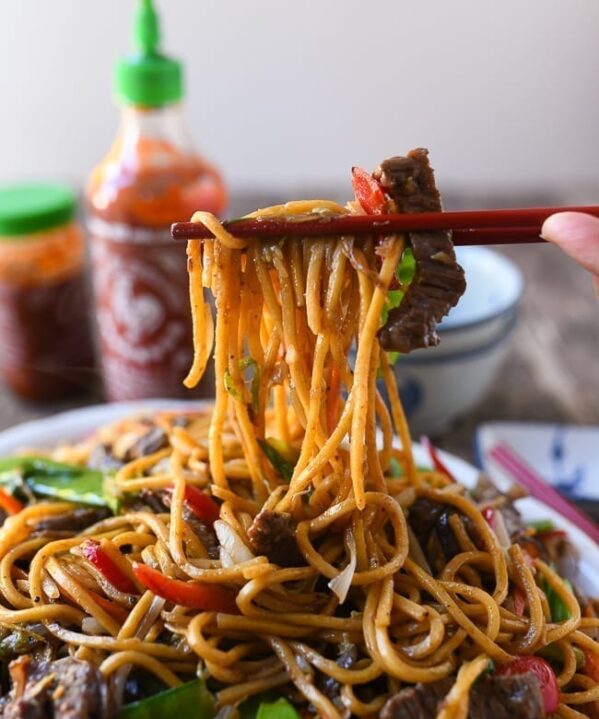 Picking up beef lo mein with chopsticks, thewoksoflife.com