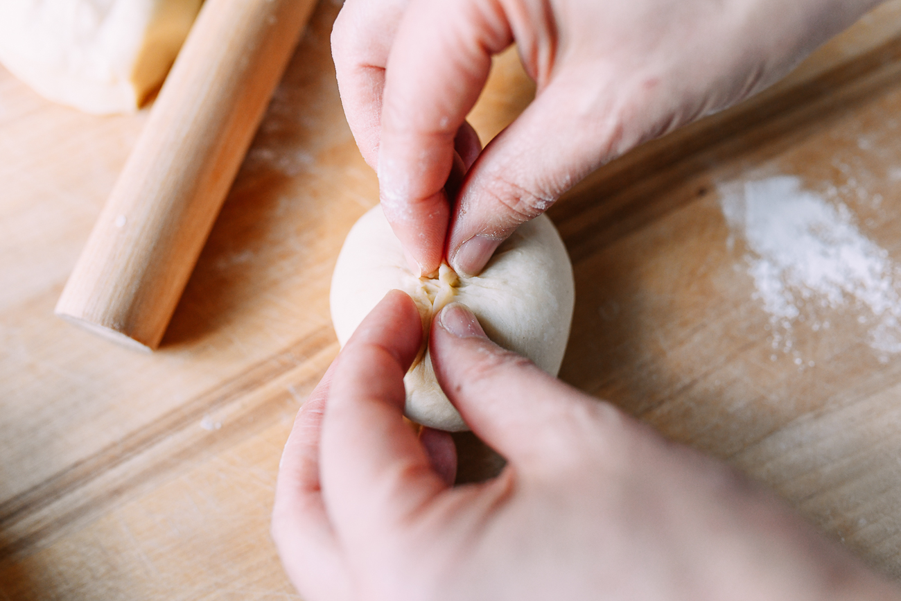 Pinching dough closed on Chinese BBQ pork bun