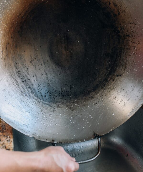 How to Wash a Wok - holding up a clean wok over the sink