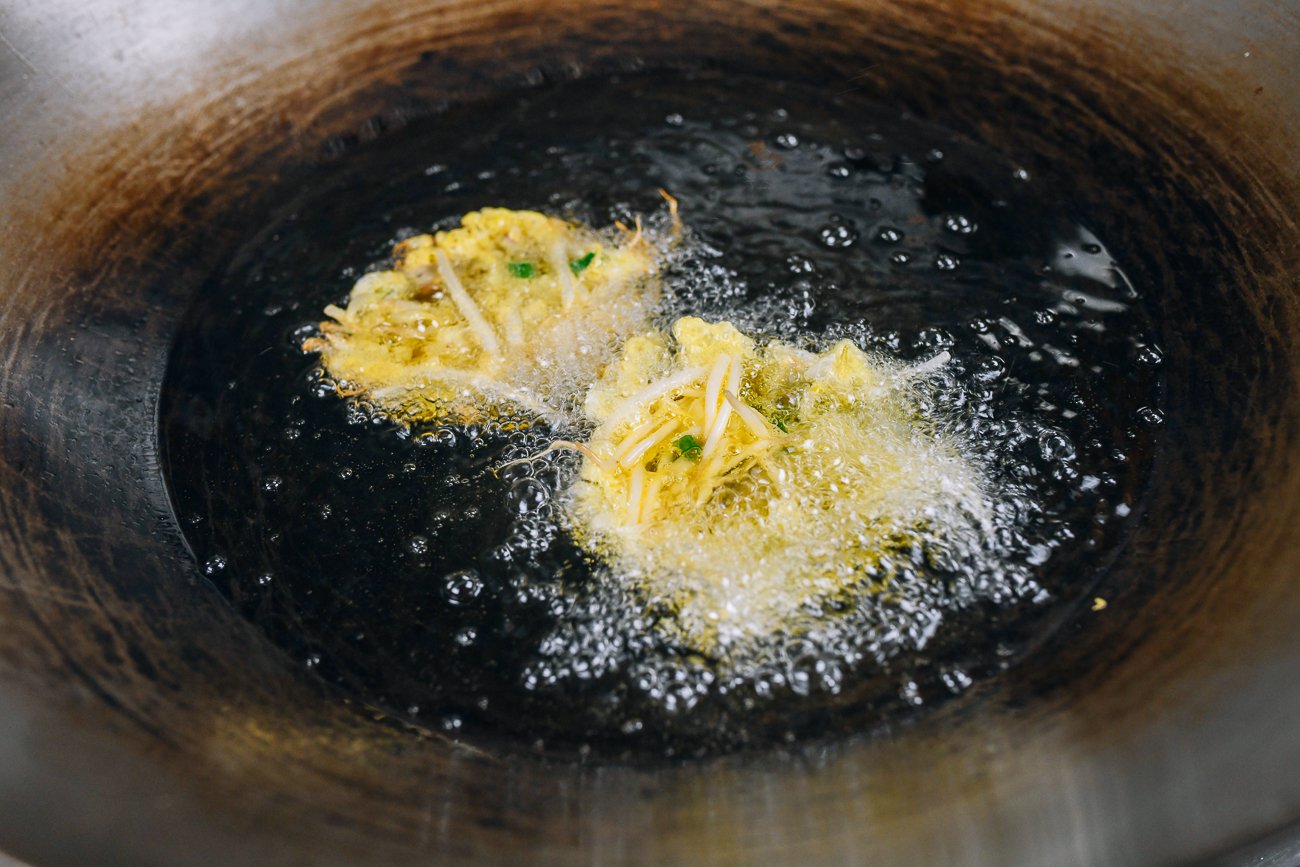 two egg foo young patties in frying oil