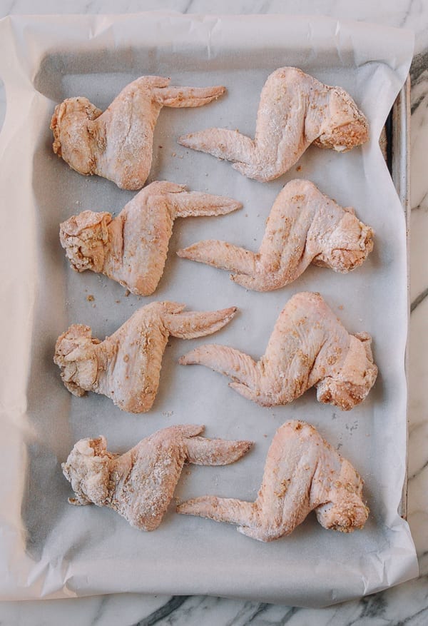 Wings laid out on parchment paper, thewoksoflife.com